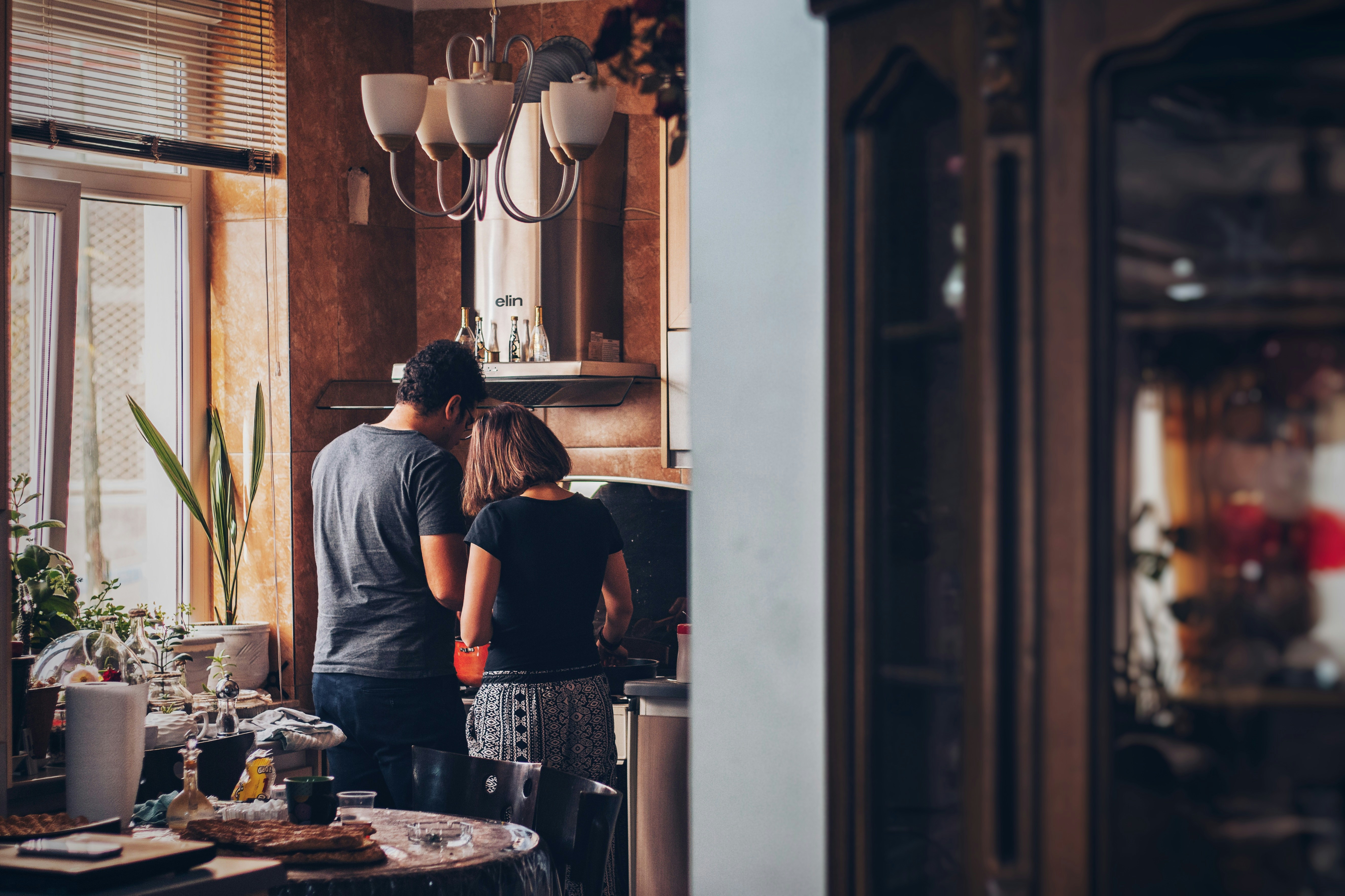 Couple cooking together in a warm, cozy kitchen