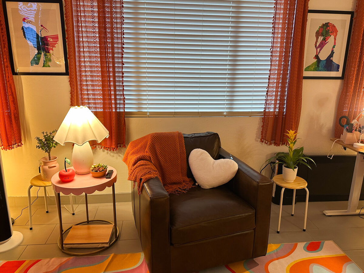 The therapy room — a cozy leather chair beside a scalloped lamp and plants